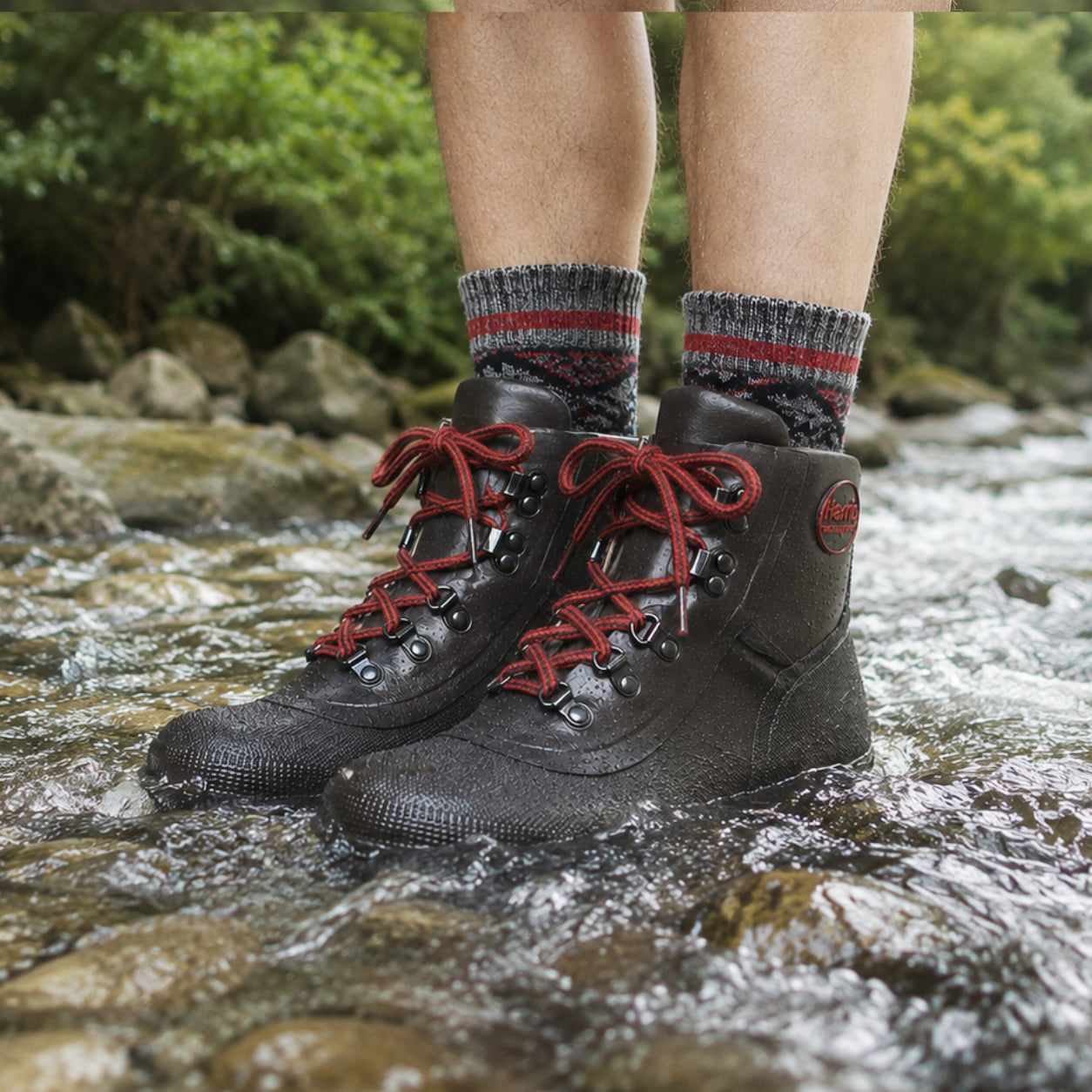 Person wearing Harris Waterproof Dryboot lace up rubber boots with red laces standing in a stream.