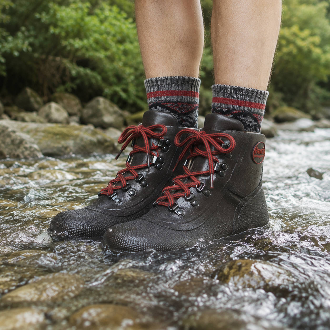 Person wearing Harris Waterproof Dryboot lace up rubber boots with red laces standing in a stream.